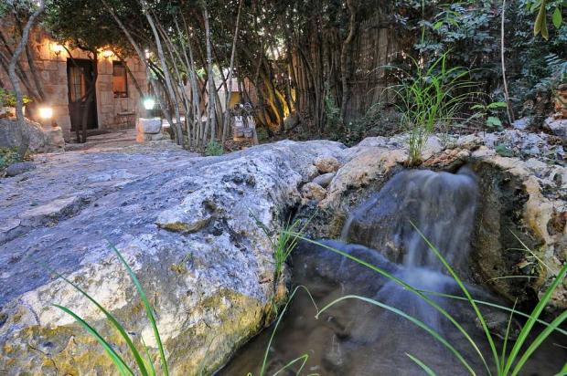 מפל מים מאבן טבעית בלב הגן והצמחייה - ברכתא