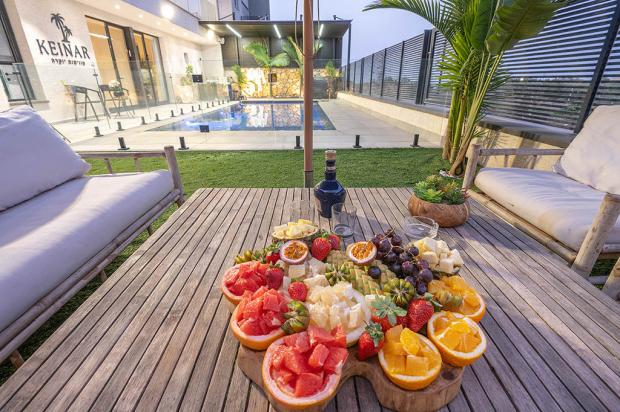 פינות ישיבה לצד הבריכה בערב - כינר סוויטות יוקרה